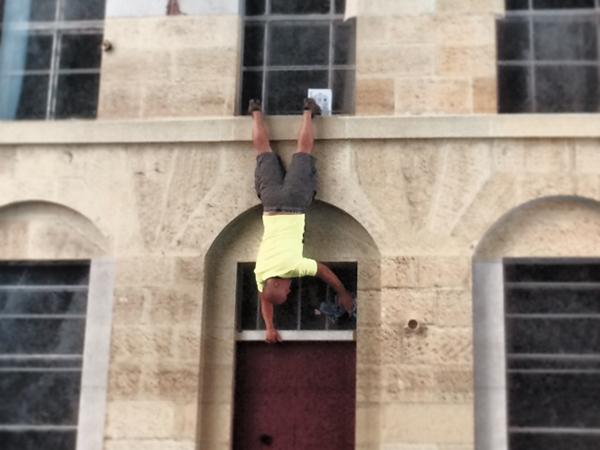 man upside down posing on a wall
